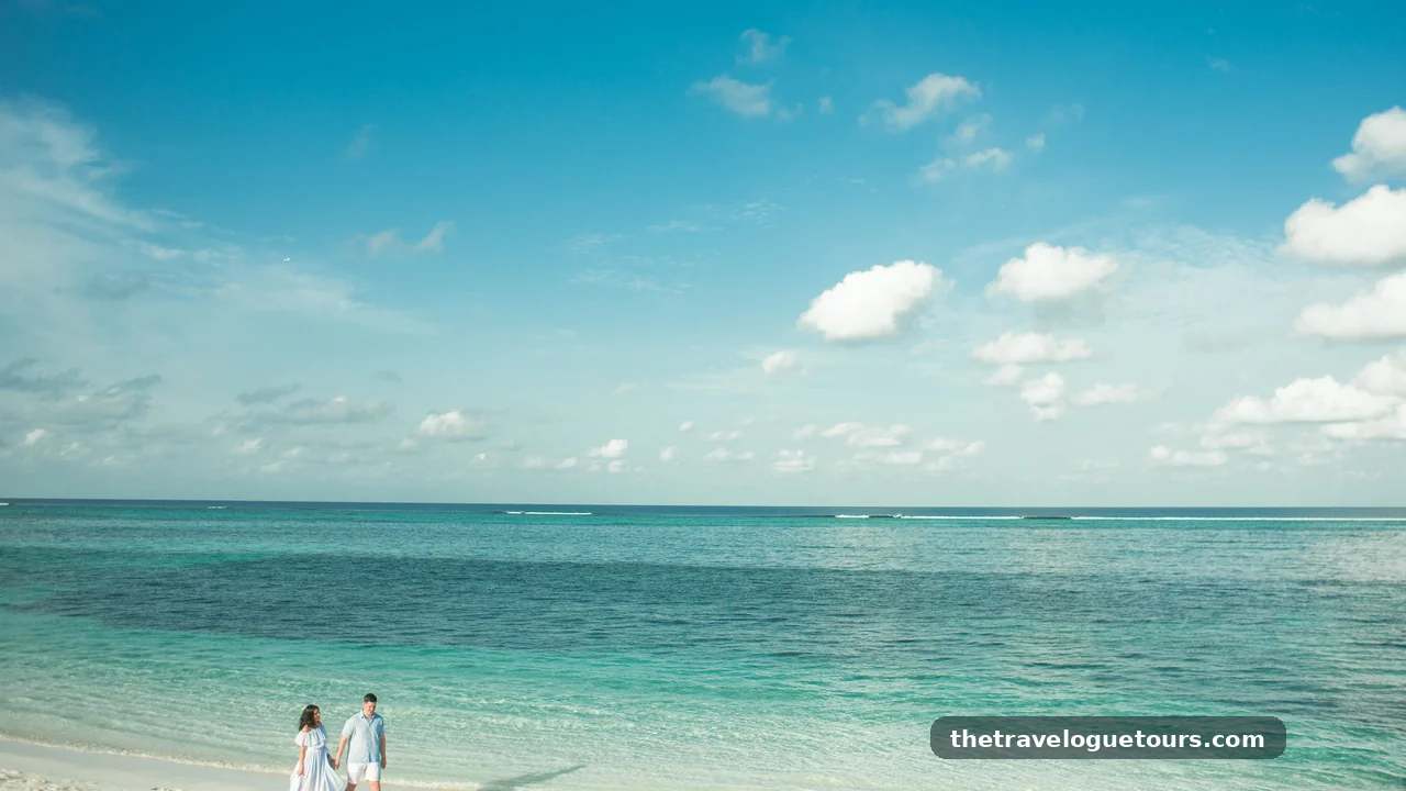 A couple walking hand in hand on a tropical beach with turquoise water