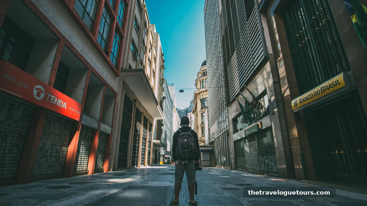 A traveler walking outdoors in bright morning sunlight in a European city