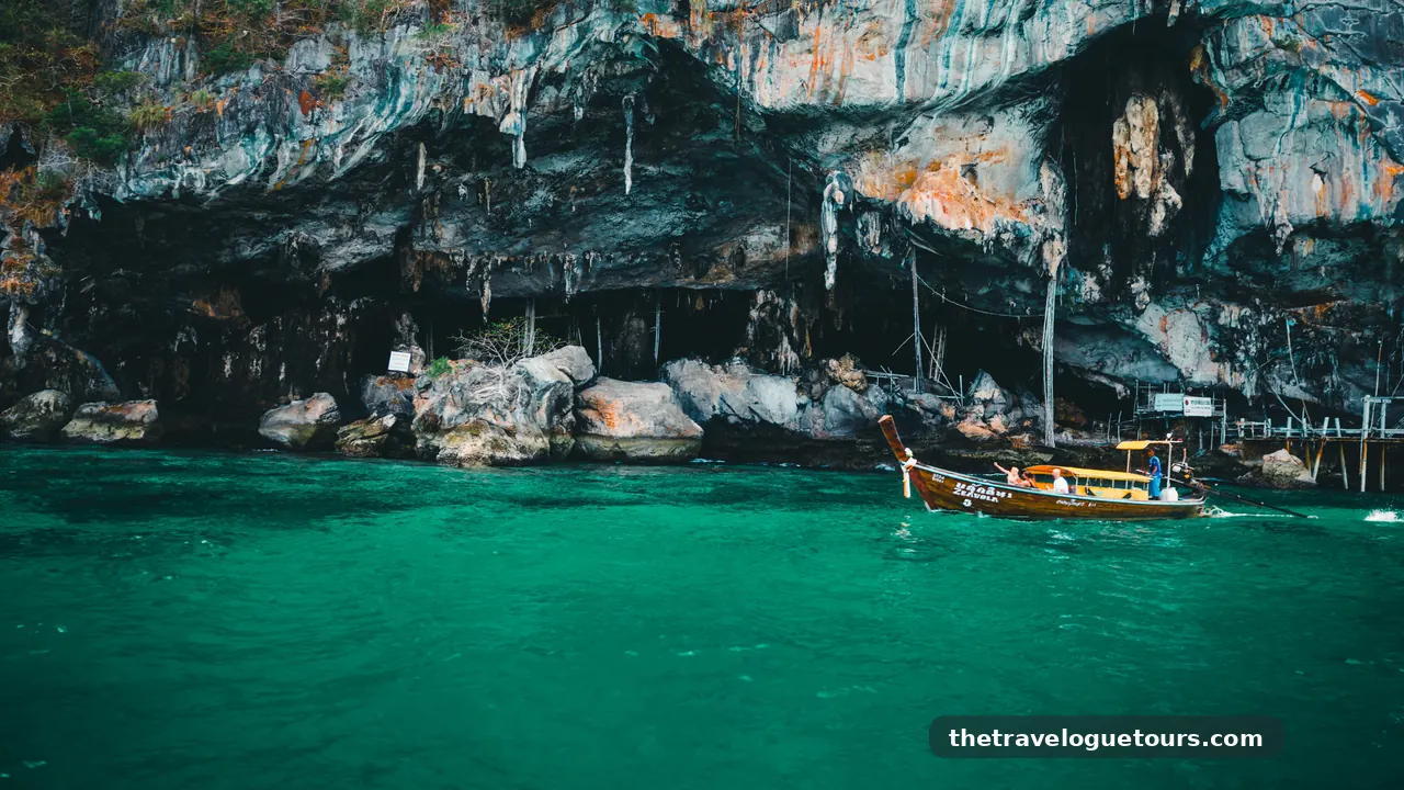 A traditional longtail boat cruises near rocky cliffs in the vibrant waters of Phuket, Thailand