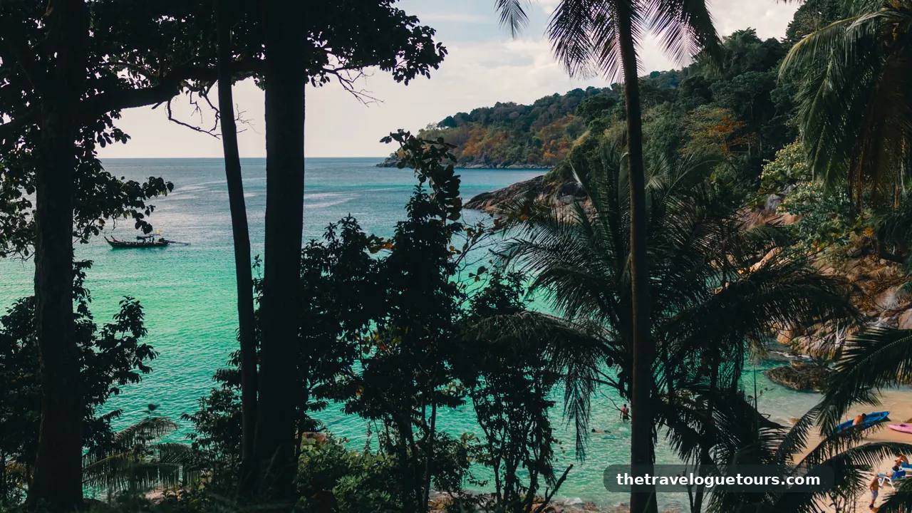 Palm trees leaning over a quiet sandy beach with clear blue water in Thailand
